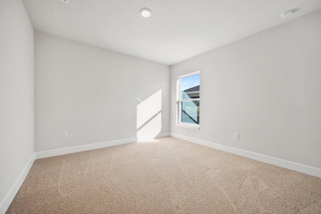 carpeted spare room with a textured ceiling