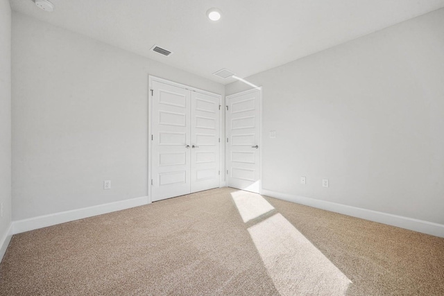 unfurnished bedroom featuring carpet flooring and a closet