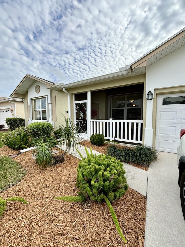 single story home featuring covered porch and a garage