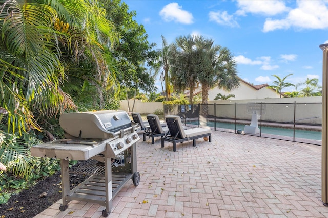 view of patio with area for grilling and a fenced in pool