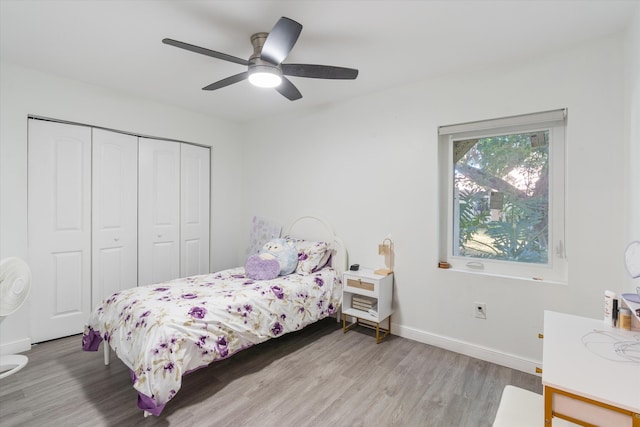 bedroom with ceiling fan, light wood-type flooring, and a closet