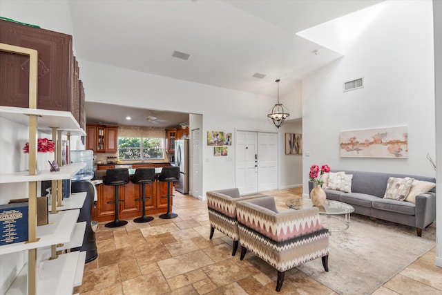 living room with sink, high vaulted ceiling, and a notable chandelier