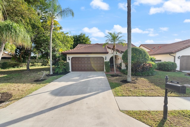 mediterranean / spanish-style home with a front lawn and a garage