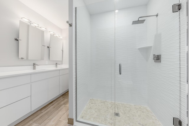 bathroom featuring hardwood / wood-style floors, vanity, and a shower with shower door