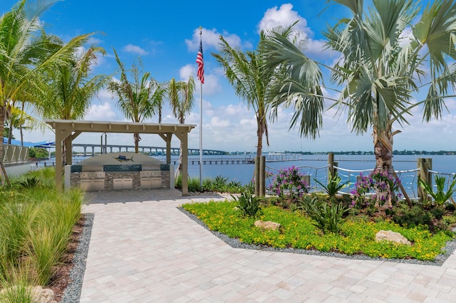 view of patio / terrace featuring a water view and an outdoor kitchen