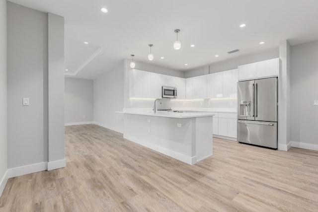 kitchen with decorative light fixtures, light wood-type flooring, white cabinetry, and stainless steel appliances