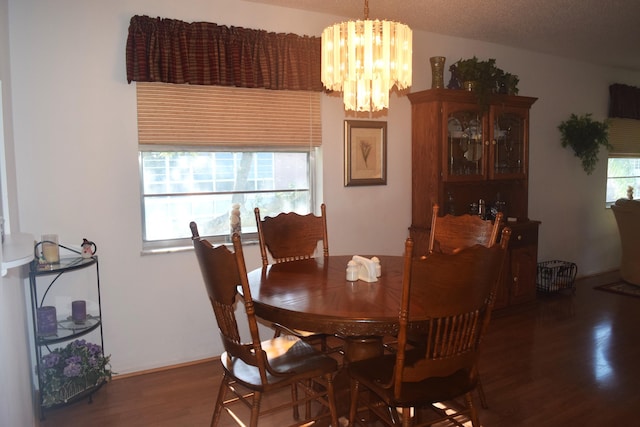 dining room featuring a notable chandelier, dark hardwood / wood-style flooring, a textured ceiling, and a wealth of natural light