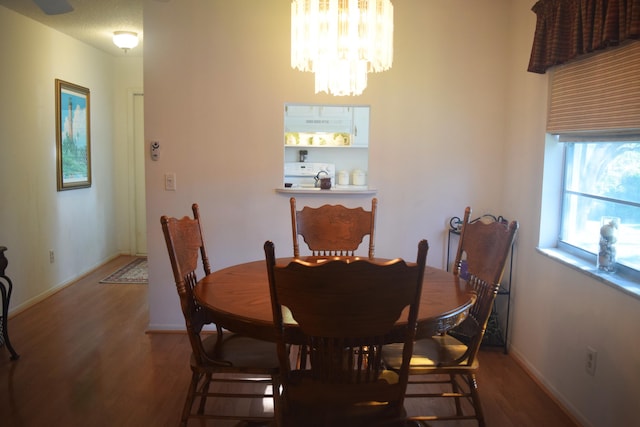 dining space featuring dark hardwood / wood-style flooring and a notable chandelier