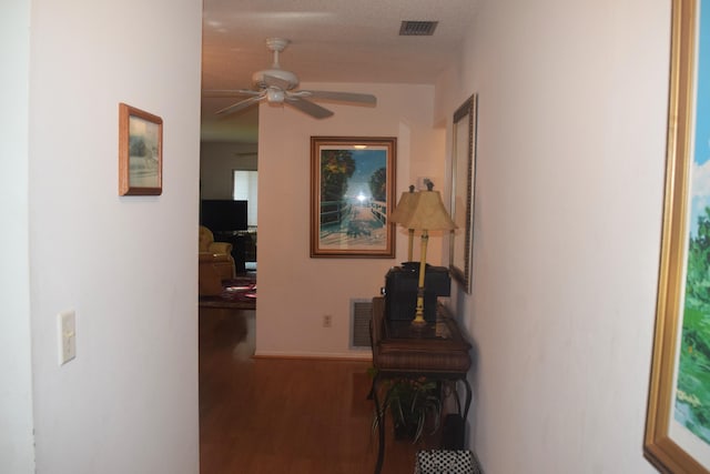 hallway with visible vents and wood finished floors