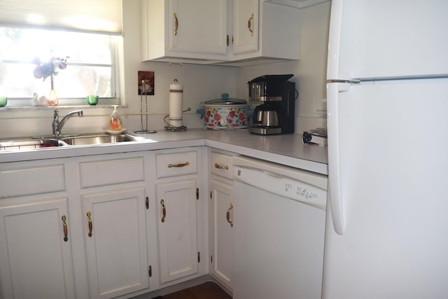 kitchen with white cabinetry, white appliances, and sink