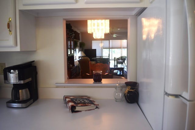 kitchen featuring ceiling fan with notable chandelier and white refrigerator