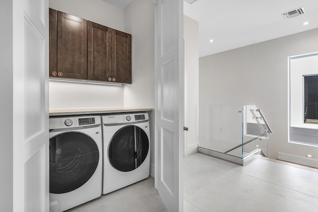 washroom featuring separate washer and dryer and cabinets