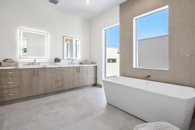 bathroom featuring a bathtub, vanity, and concrete floors