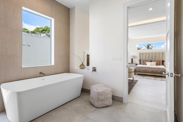 bathroom with concrete flooring and a bath