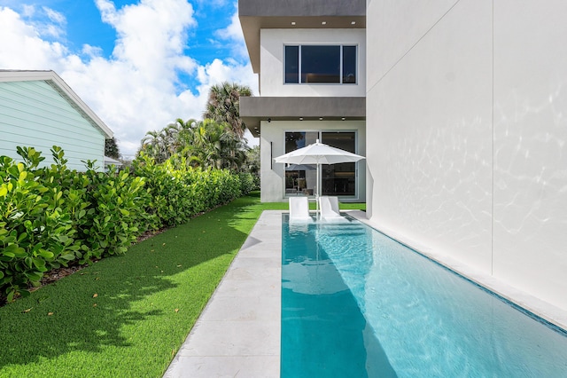 view of swimming pool featuring a yard