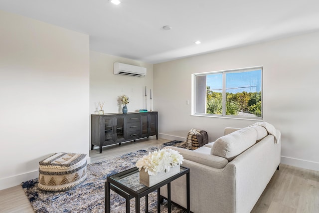 living room with a wall mounted air conditioner and light hardwood / wood-style floors