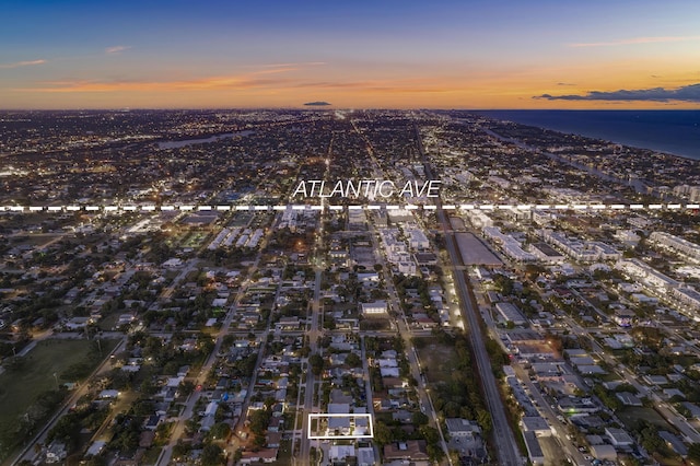 aerial view at dusk featuring a water view