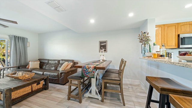 living room featuring ceiling fan and light hardwood / wood-style floors