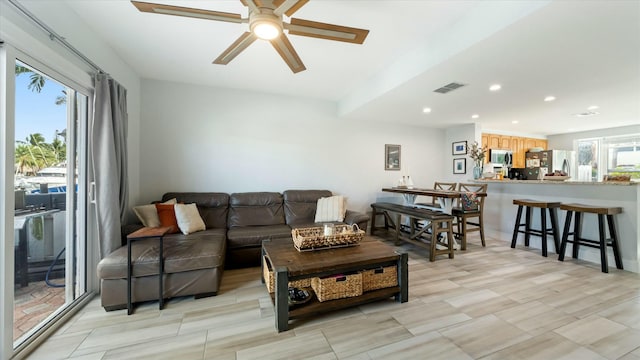 living room with ceiling fan and a healthy amount of sunlight