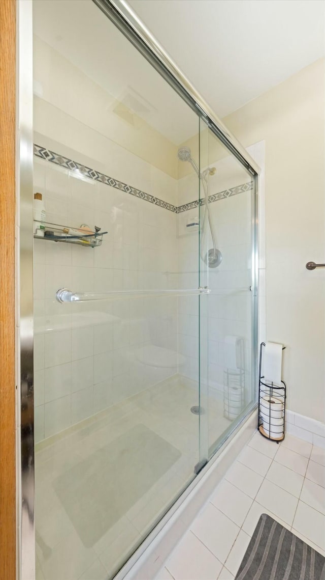 bathroom featuring tile patterned floors and a shower with shower door