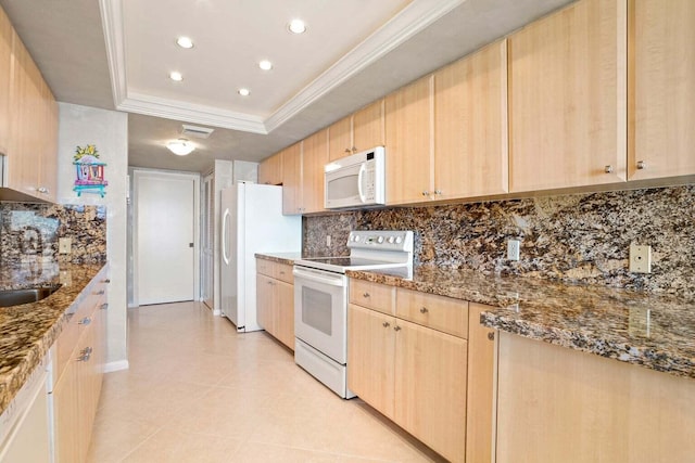 kitchen featuring light brown cabinets, a raised ceiling, white appliances, and stone counters