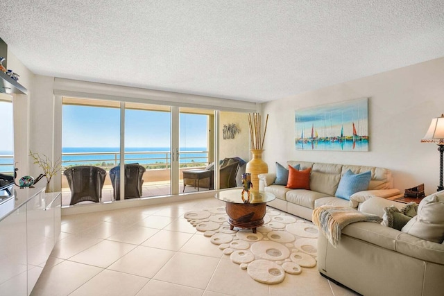 living room with light tile patterned floors, a textured ceiling, and a water view