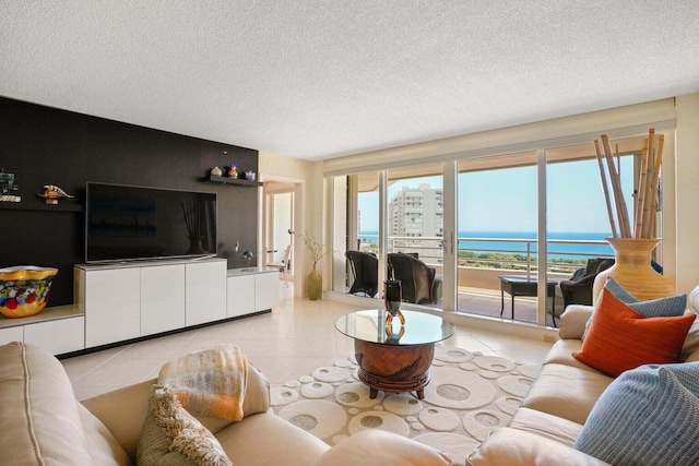 tiled living room with a water view and a textured ceiling