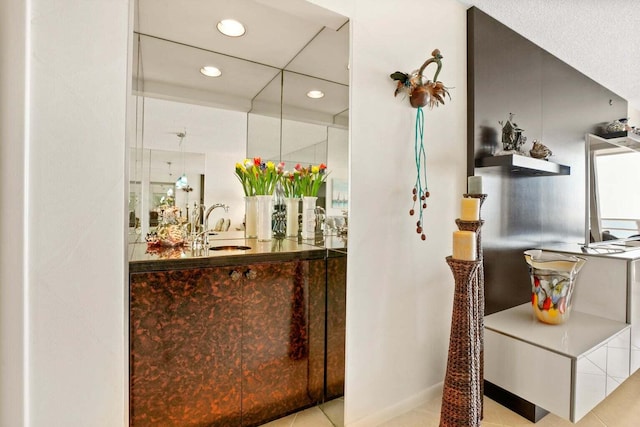 bar featuring sink and light tile patterned flooring