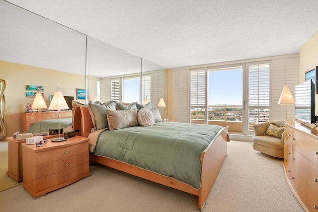 bedroom with light colored carpet and a textured ceiling