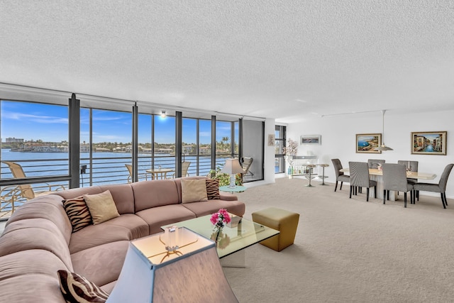 living room featuring floor to ceiling windows, a water view, carpet floors, and a textured ceiling