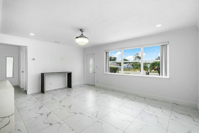 unfurnished living room featuring crown molding