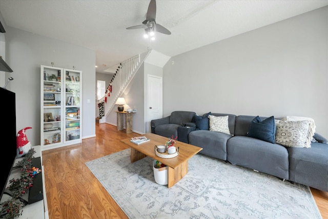 living room with ceiling fan, wood-type flooring, and lofted ceiling