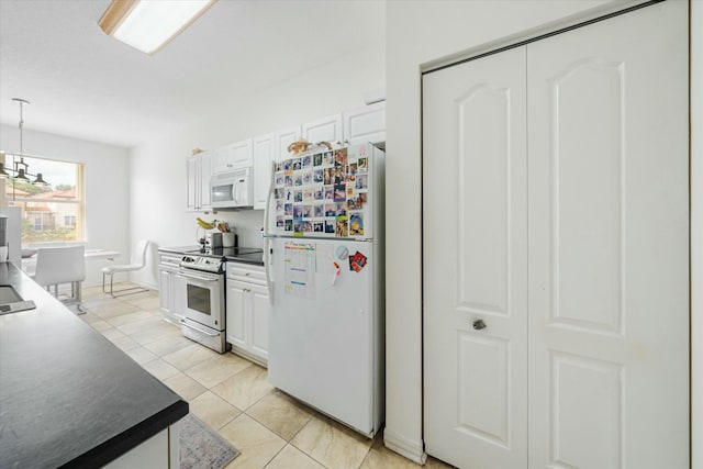 kitchen with white appliances, light tile patterned floors, a notable chandelier, white cabinets, and hanging light fixtures