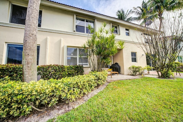 rear view of property featuring a lawn