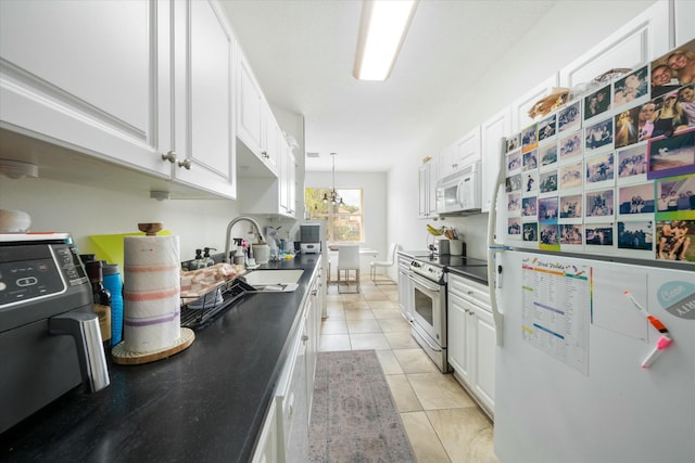 kitchen with sink, white cabinets, white appliances, and light tile patterned floors