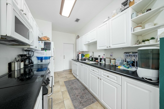 kitchen featuring electric stove, white cabinetry, and sink