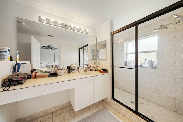 bathroom with ceiling fan, tile patterned flooring, vanity, and a shower with shower door