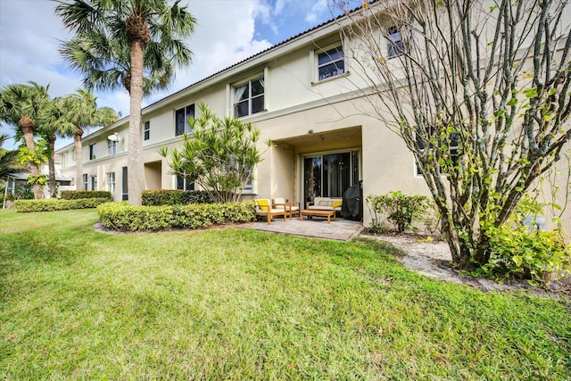 rear view of property featuring a yard and a patio