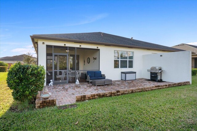 back of house with a sunroom, a patio area, and a yard