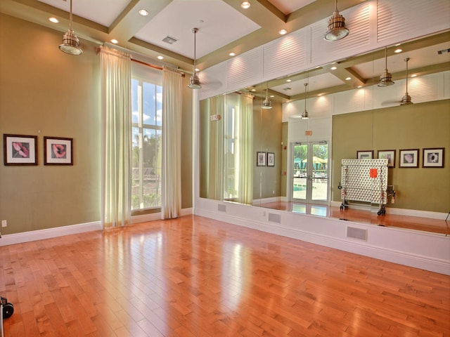 exercise room with ceiling fan, a wealth of natural light, and light hardwood / wood-style flooring