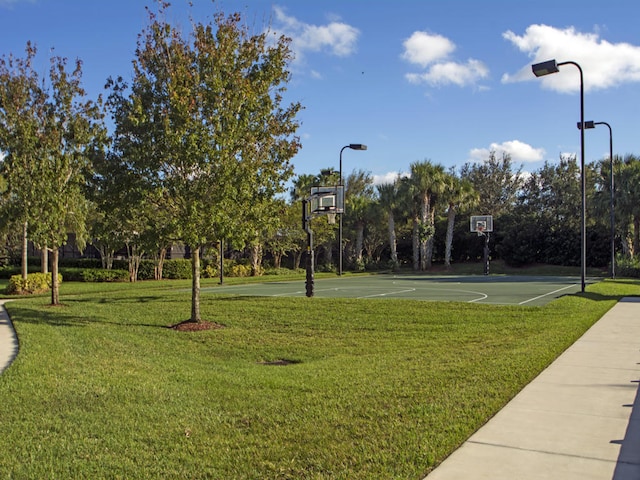 view of basketball court with a yard