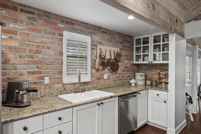 kitchen featuring white cabinetry, sink, light stone counters, stainless steel dishwasher, and dark hardwood / wood-style floors