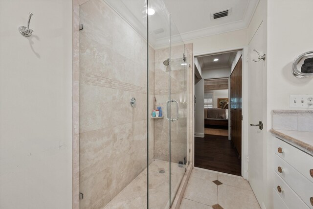 bathroom featuring tile patterned flooring, a shower with door, and ornamental molding