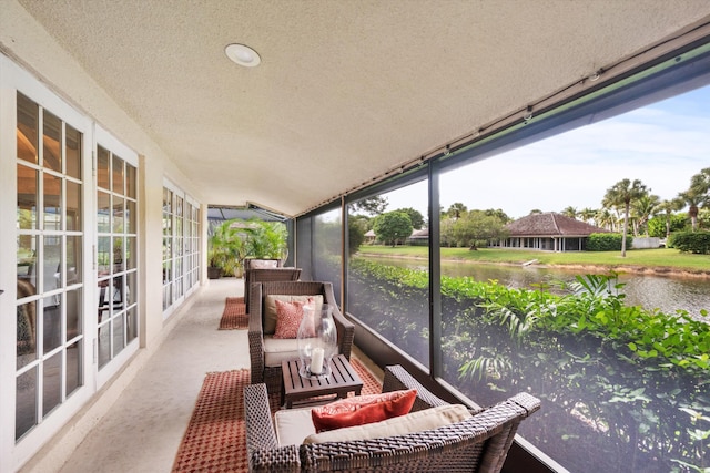 sunroom featuring a water view