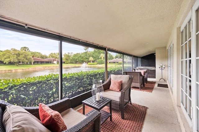 sunroom / solarium featuring a water view