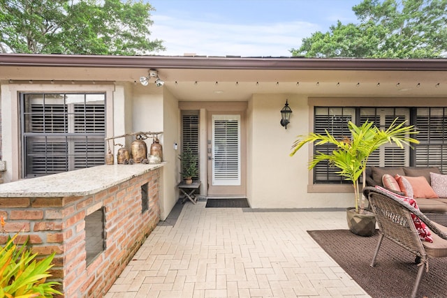 doorway to property featuring exterior bar and a patio area