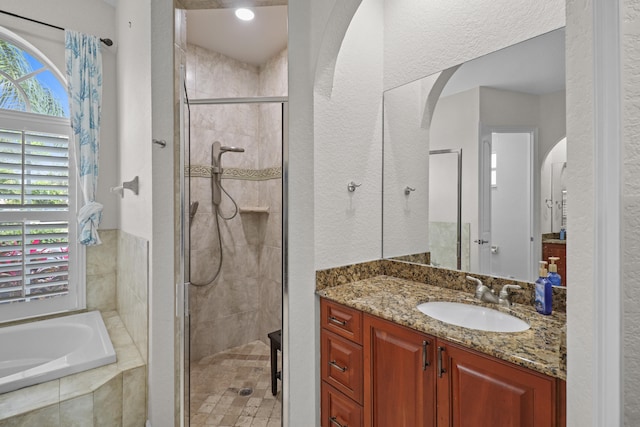 bathroom featuring vanity and shower with separate bathtub