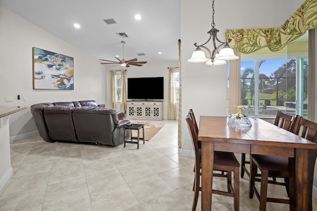 tiled dining room featuring ceiling fan with notable chandelier and vaulted ceiling