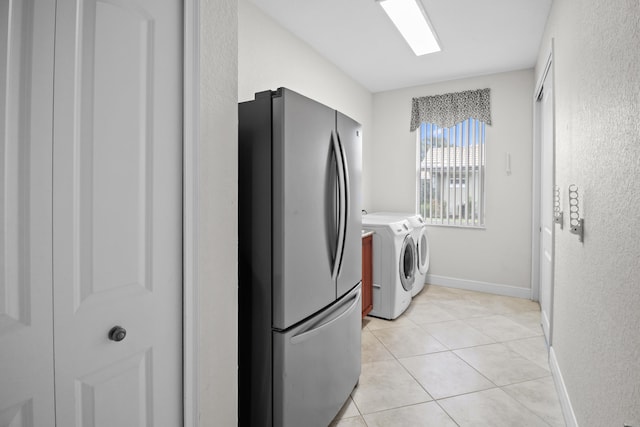 laundry room featuring light tile patterned floors and washer and clothes dryer