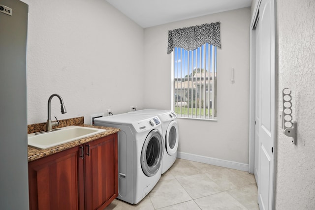 laundry area featuring washer and clothes dryer, light tile patterned flooring, cabinets, and sink